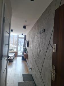 a hallway with a stone wall and a door at Mały Apartament Ustroń in Ustroń