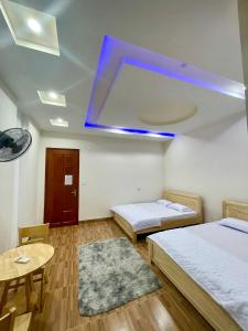 a room with two beds and a blue light on the ceiling at Hà Linh Motel in Vung Tau