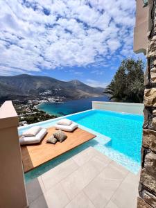 una piscina con vista sull'acqua e sulle montagne di Aegialis Hotel & Spa ad Aegiali