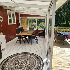 una terraza de madera con mesa y sillas. en Nice holiday home in Tallbacken by Bolmen, Ljungby, en Ljungby