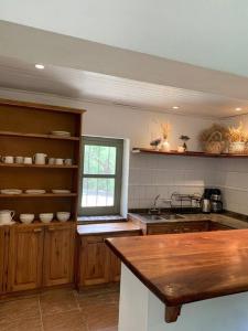 a kitchen with wooden cabinets and a sink and a window at Casa de Piedra in La Cumbre