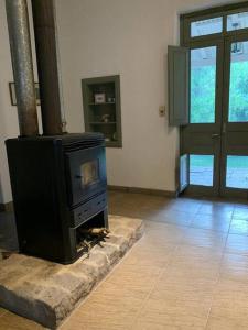 a fireplace in a living room with a stove at Casa de Piedra in La Cumbre