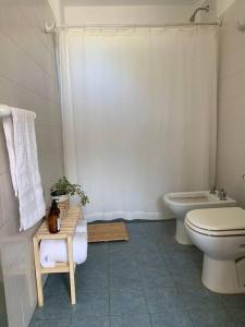 a bathroom with a toilet and a tub and a sink at Casa de Piedra in La Cumbre