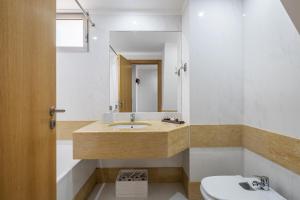 a bathroom with a sink and a toilet and a mirror at Casa Anaim by Homie in Lapeiras +17 photos