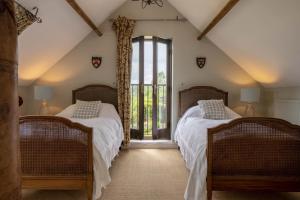 two beds in a room with a window at Five Acres in Thirsk