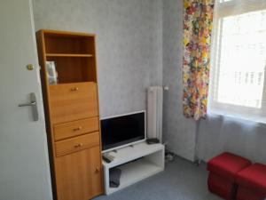 a small room with a tv and a dresser with a dresser at Time for Cracow in Krakow