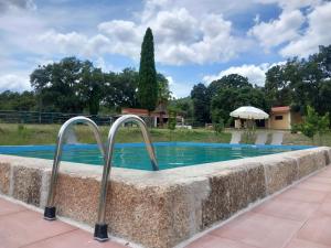 a swimming pool in a stone wall with two metal handles at Casa da Vinha in Castelo Novo