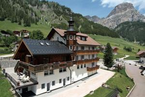 a large building with a mountain in the background at Piz Alpin B&B in Colfosco