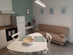 uma mesa branca e cadeiras numa cozinha com um sofá em Casa di Monique 1 em Bari Palese