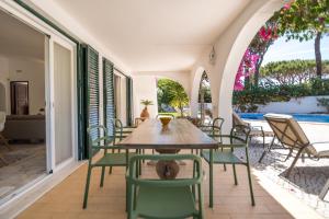 a patio with a table and chairs and a pool at Traditional 3 bedroom villa with great pool in the heart of Vale do Lobo in Vale do Lobo