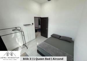 sypialnia z łóżkiem w białym pokoju w obiekcie Adwa Homestay Kijal Private Pool Mini Golf w mieście Kampong Darat Kijal