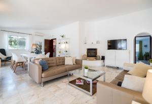 a living room with a couch and a table at Traditional 3 bedroom villa with great pool in the heart of Vale do Lobo in Vale do Lobo