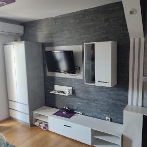 ein Wohnzimmer mit einem TV an einer Backsteinwand in der Unterkunft Sofia's Apartments in Biograd na Moru