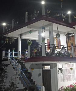 a house with a staircase and a balcony at night at Valley View Homestay in Darjeeling