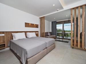 a bedroom with a large bed and a balcony at Hotel Athina in Agios Stefanos