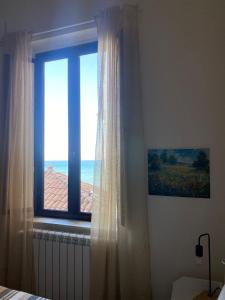 a bedroom with a window with a view of the ocean at AmMARE in Crotone
