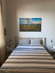 uma cama num quarto com um quadro na parede em AmMARE em Crotone