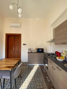 a kitchen with a wooden table and a table and a dining room at AmMARE in Crotone