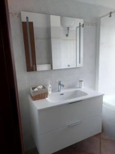 une salle de bains avec un lavabo blanc et un miroir dans l'établissement Appartamento vista mare, 100mt dall'Ospedale Pediatrico, a 200mt dal mare, 1h da Roma Termini, à Santa Marinella
