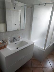 une salle de bain blanche avec lavabo et douche dans l'établissement Appartamento vista mare, 100mt dall'Ospedale Pediatrico, a 200mt dal mare, 1h da Roma Termini, à Santa Marinella