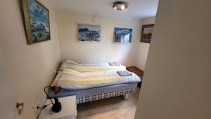 een kleine slaapkamer met een bed en foto's aan de muur bij Flott leilighet i stille og rolig område, med gratis privat parkering! in Stavanger