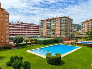 uma grande piscina num quintal com edifícios altos em Vivalidays Lora - Santa Susanna em Santa Susanna