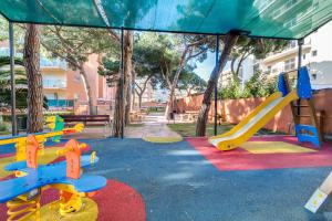 um parque infantil com escorrega num parque em Vivalidays Lora - Santa Susanna em Santa Susanna