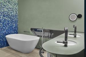 a bathroom with a white tub and a sink at JW Marriott Hotel Istanbul Marmara Sea in Istanbul