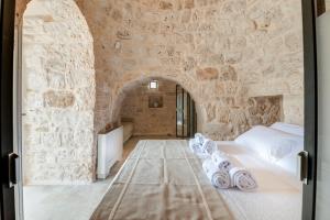 a bedroom with a bed in a stone wall at Trullo Don Giulio in Francavilla Fontana