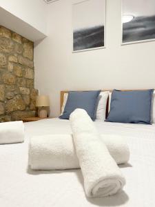 a bedroom with two beds with white sheets and blue pillows at Ostraco Aphytis in Afitos