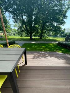 a picnic table and chairs on a deck with a park at BIG BERRY Kolpa - Isabella Premium House in Gradac