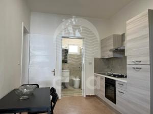 a kitchen with a table and a sink and a bathroom at Villetta Trama- Spiaggia a 100m in Porto Cesareo