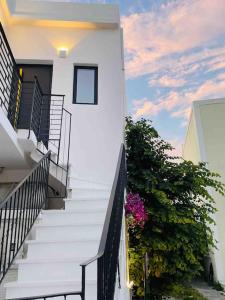a stairway leading up to a white building with flowers at Sol living in Tinos