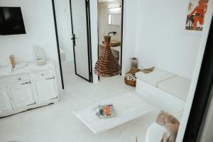 a white living room with a mirror and a white couch at Sol living in Tinos