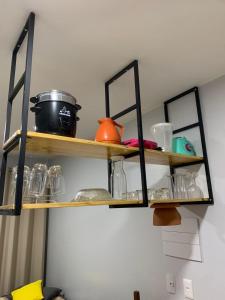 a kitchen shelf with glasses and a pot on it at Lagoa Quente Flat Service in Caldas Novas