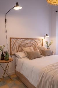 una camera con letto bianco e testiera in legno di apartamentos junto a jardines del triunfo a Granada