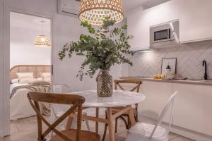 una cucina e una sala da pranzo con tavolo e vaso con fiori di apartamentos junto a jardines del triunfo a Granada
