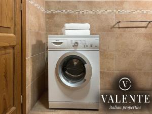 a washing machine in a bathroom next to a wall at Via Ruga degli Orlandi - Valente Italian Properties in Pescia