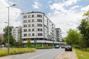 um edifício branco alto no lado de uma rua em Woronicza Premium Apartments - 80 em Varósvia