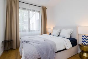 um quarto branco com uma cama grande e uma janela em Woronicza Premium Apartments - 80 em Varósvia