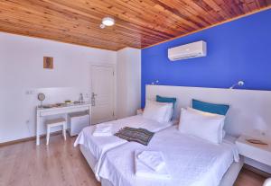 1 dormitorio con 1 cama grande y pared azul en Elit Hotel Kas, en Kas
