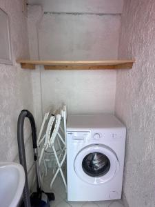 a washing machine in a small room with a shelf at Studio les Iris climatisé, entre mer et collines, classé meublé de tourisme 2 étoiles in Allauch