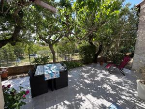 a patio with a table and a chair and trees at Studio les Iris climatisé, entre mer et collines, classé meublé de tourisme 2 étoiles in Allauch