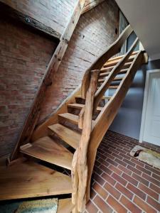 a wooden spiral staircase in a brick wall at Schwalbenwohnung 