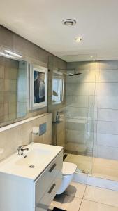a bathroom with a sink and a toilet and a shower at The Signature Apartments, Accra Ghana in Accra