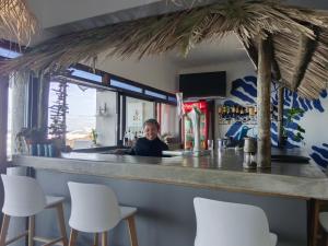 ein Junge sitzt an einer Bar in einem Restaurant in der Unterkunft Sea Shell in Morganʼs Bay
