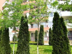 a building with trees in front of it at Kalina Private Apartments in Riviera Fort Beach, Ravda in Ravda