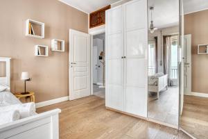 a bedroom with a large white closet and a mirror at ALTIDO Delightful flat with terrace in Milan