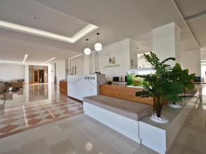 a lobby with a counter with a plant at Hotel Athina in Agios Stefanos