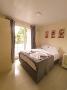 um quarto com uma cama grande e uma janela em Residencial Terrazas em Florianópolis